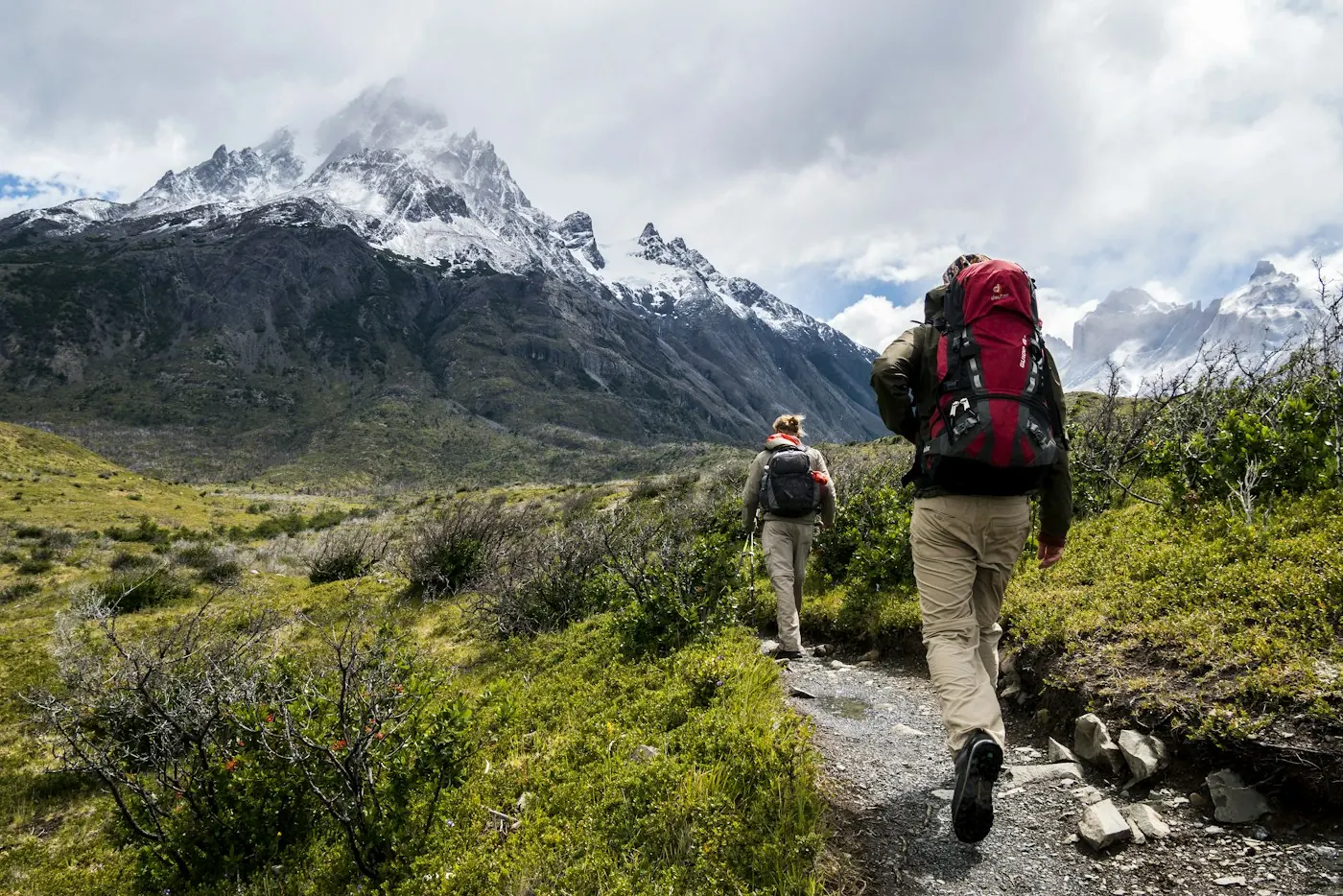 Excursionistas con mochila caminando por un sendero de montaña